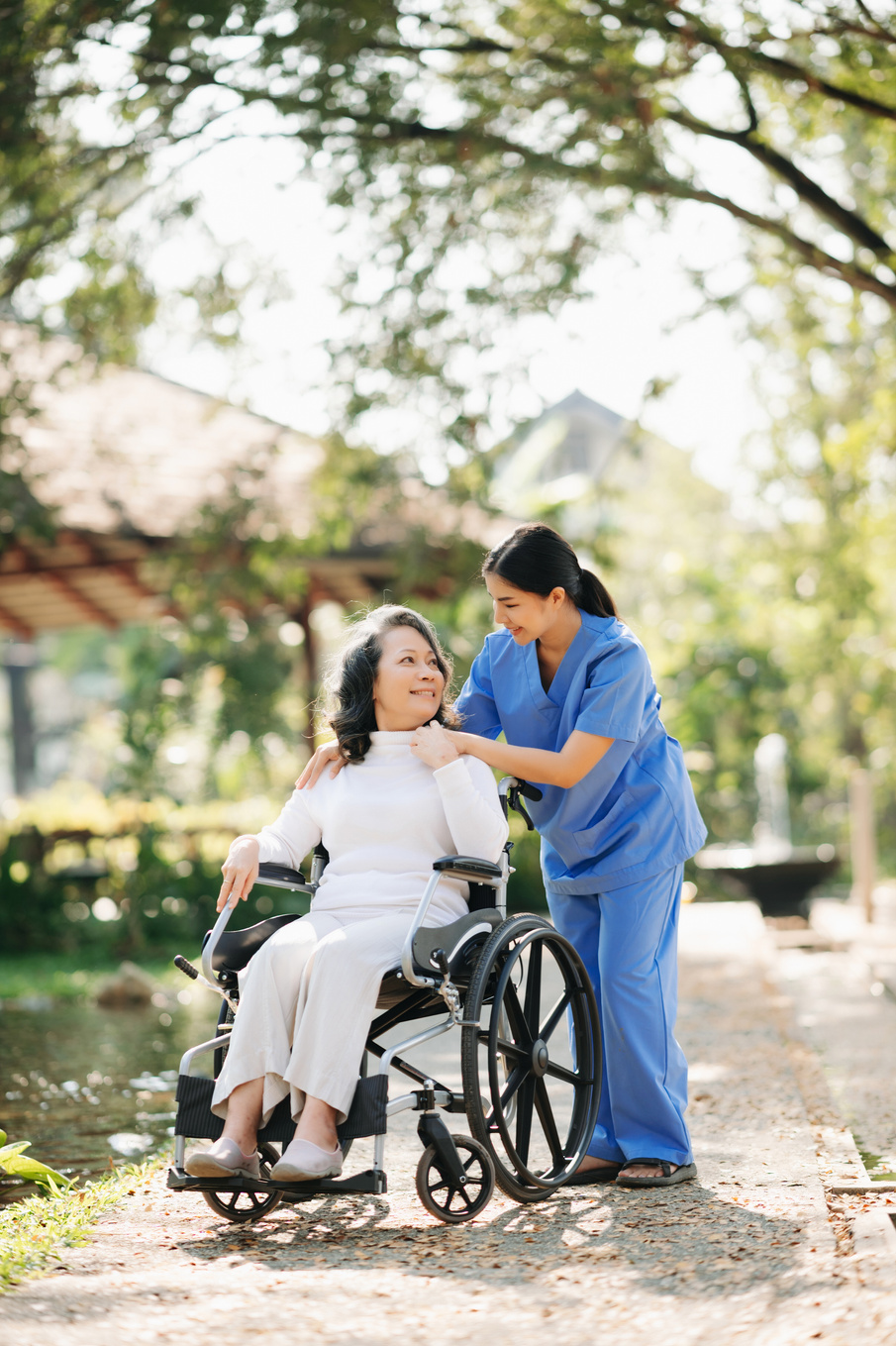 Elderly asian senior woman on wheelchair with Asian careful care